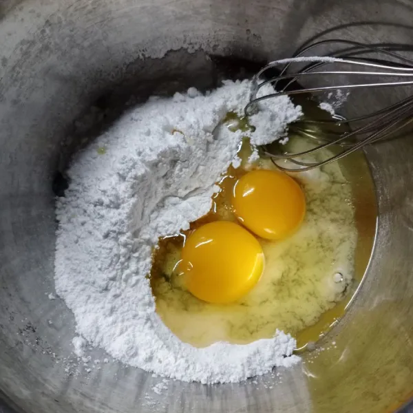 Masukkan gula dan telur ke dalam wadah. Kemudian kocok sampai gula larut.
