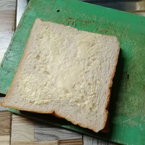Tumpuk roti menjadi satu. Oles lagi dengan margarin.