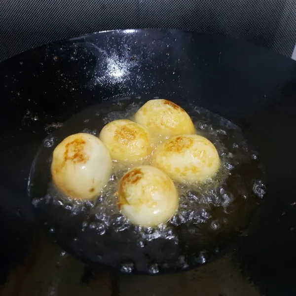 Goreng sebentar telur rebus sampai berkulit. Angkat dan tiriskan.