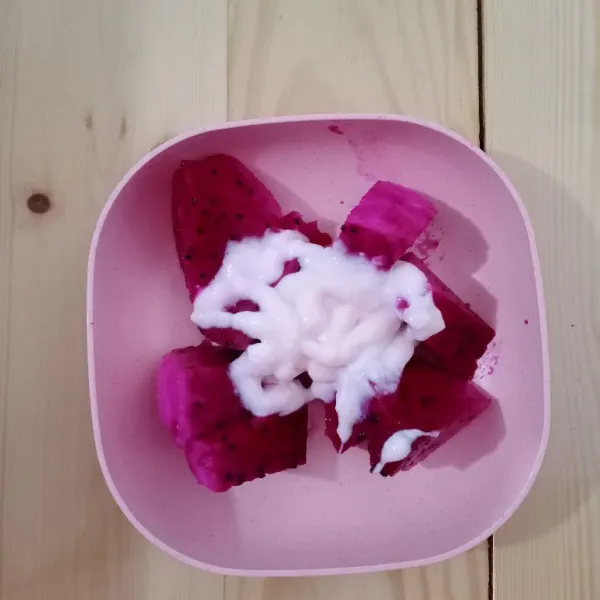 Campurkan buah naga dan yoghurt. Haluskan dengan garpu.