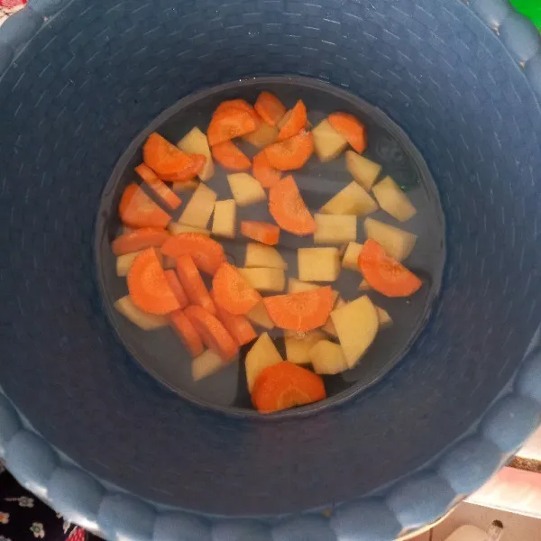 Cuci bersih kentang, kupas kulitnya dan potong kecil, potong-potong juga wortel.