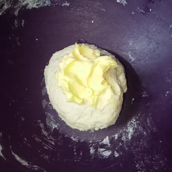 Masukkan mentega dan garam, kemudian uleni lagi sampai adonan benar-benar kalis.