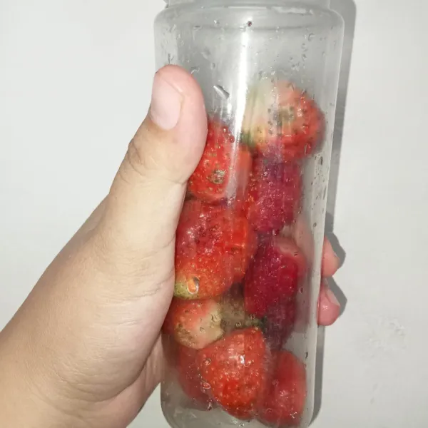 Potong bagian daun strawberry kemudian masukkan strawberry ke dalam mini blender.