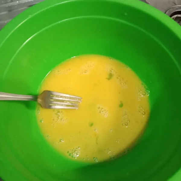 Dalam wadah lain, kocok lepas telur bersama vanila bubuk dengan garpu.