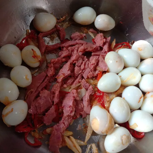 Masukkan telur puyuh rebus dan kornet sapi. Aduk rata.