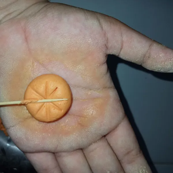 Ambil secukupnya adonan orange kemudian bulatkan dan tekan menggunakan tusuk gigi lakukan hingga ke bawah supaya berbentuk sekatan labu.