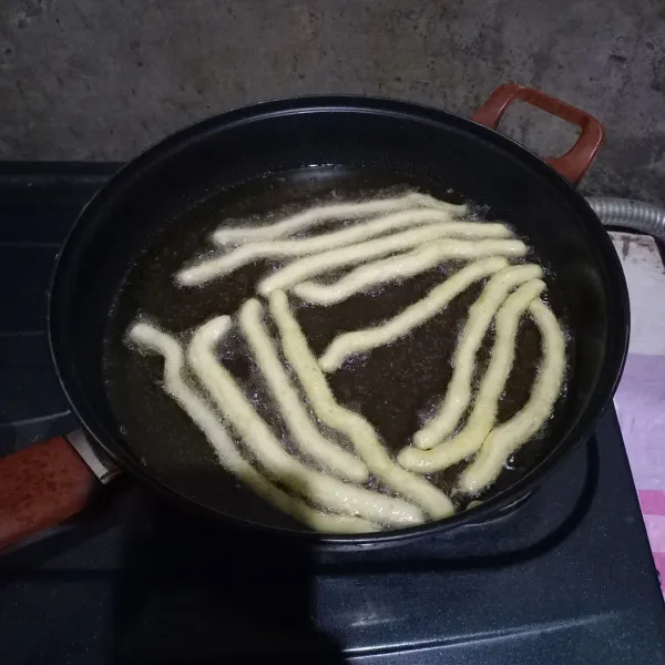 Goreng adonan kentang berbentuk panjang sampai kecokelatan. Sajikan dengan saus dan cabai bubuk.