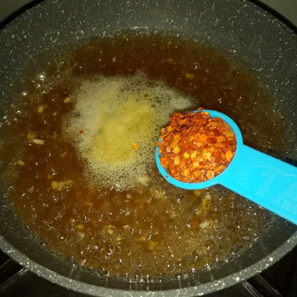 Masukkan chili flakes, garam dan lada, masak sampai kuah berwarna merah.