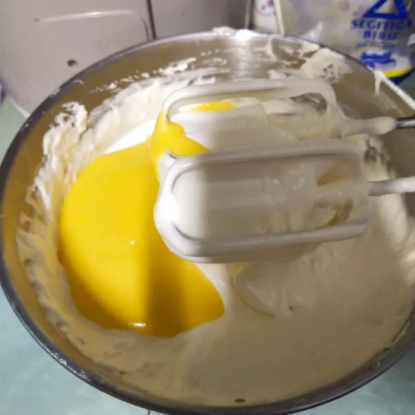 Kemudian setelah putih kental dan berjejak, masukkan mentega yang sudah dilelehan dan didinginkan, aduk sampai rata.