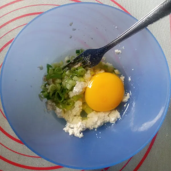Tambahkan daun bawang dan telur, aduk rata.