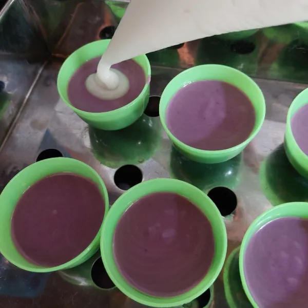 Tuang adonan ungu ke dalam cetakan yang sudah di olesi minyak, lalu beri larutan putih di atasnya.