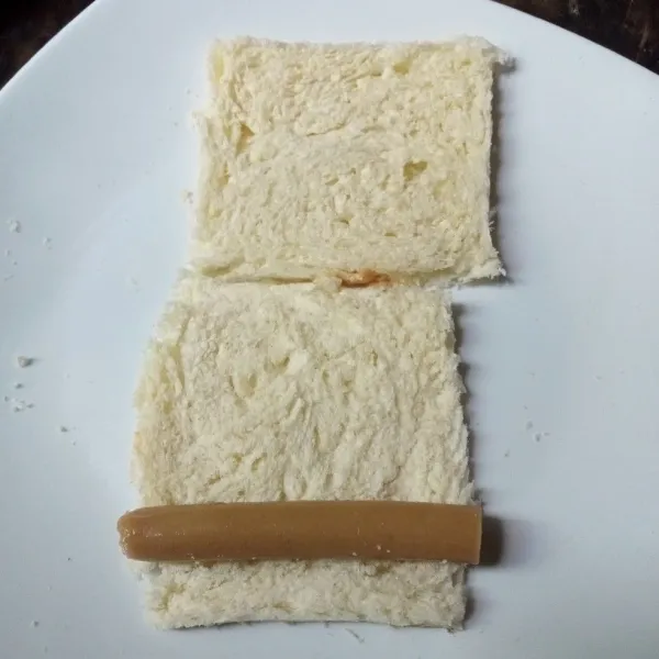 Letakkan sosis di atas roti dan gulung.