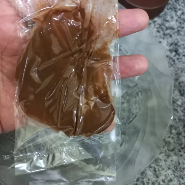 Siapkan plastik masukkan cokelat oles ke dalamnya, tekan cokelat supaya menempel pada plastik.