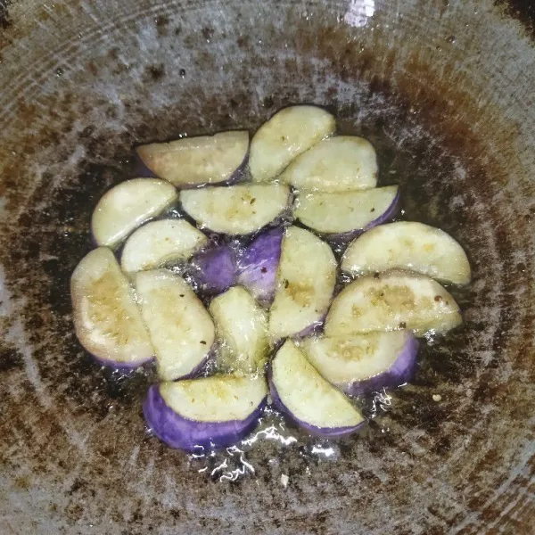 Potong-potong terong ungu sesuai selera lalu goreng terong hingga matang.