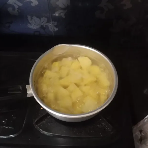 Kupas dan potong-potong kentang lalu rebus hingga matang, angkat, tiriskan.