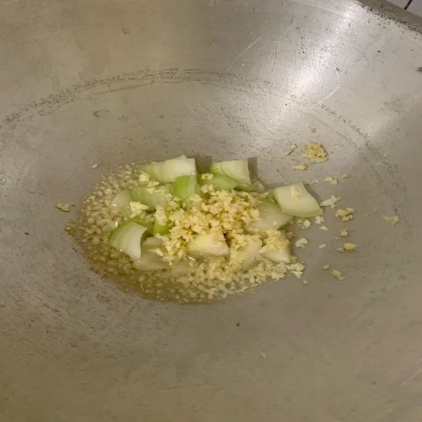 Tumis bawang putih hingga harum, lalu tambahkan bawang bombay. Aduk hingga bawang bombay layu.
