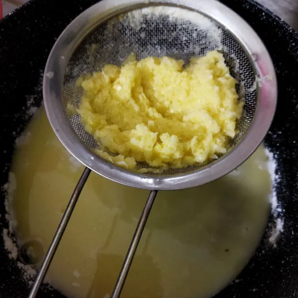Saring di atas panci berisi tepung.