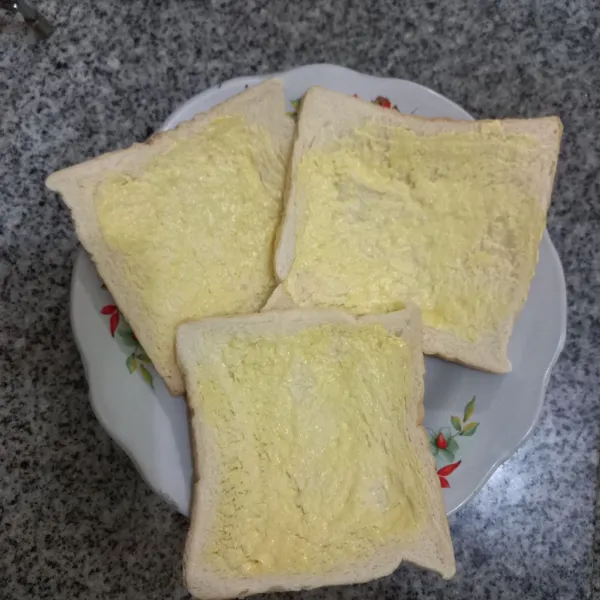 Olesi salah satu bagian roti dengan margarin secukupnya, ratakan.