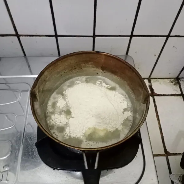 Setelah mendidih tambahkan tepung terigu, aduk hingga tercampur rata dan kalis. Dinginkan.