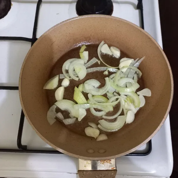 Panaskan minyak, tumis irisan bawang putih dan bawang bombay hingga harum.