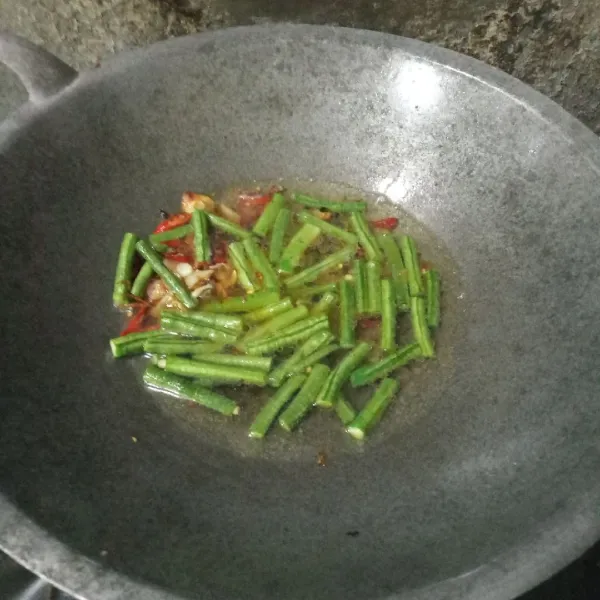 Tuang air, biarkan mendidih lalu masukkan kacang panjang, masak hingga setengah matang.