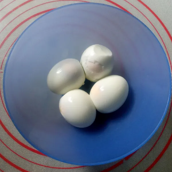 Rebus telur sampai matang, kupas dan kerat jangan tembus.
