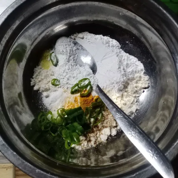 Dalam wadah masukkan terigu, tepung beras, garam, kaldu bubuk, lada bubuk, kunyit bubuk, ketumbar bubuk, bawang putih bubuk dan daun bawang.