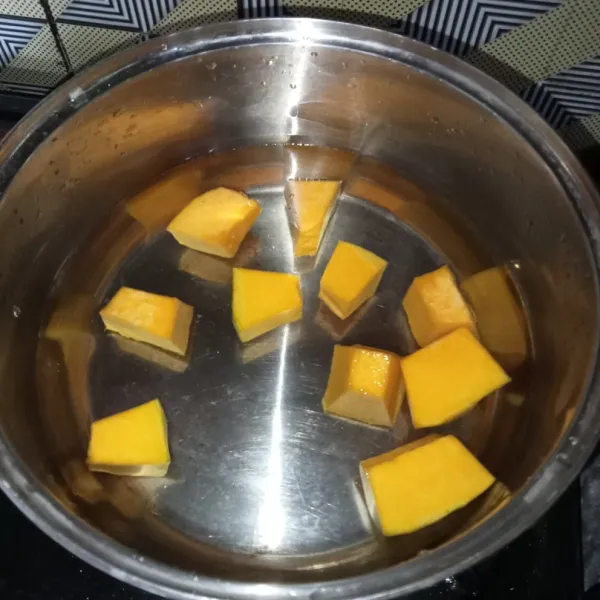 Rebus labu kuning dan air di panci.