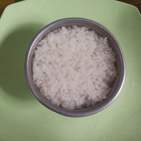 Kemudian tambahkan nasi secukupnya sambil ditekan-tekan lalu tambahkan air kaldu hingga nasi terendam.