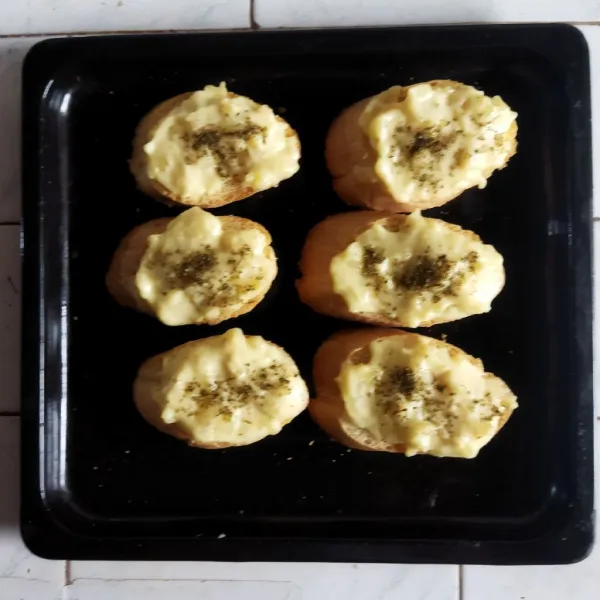 Melted Mashed Potato siap disajikan diatas roti baguette dengan taburan parsley sesuai selera. Panggang sejenak di oven yang sudah dipanaskan untuk hasil yang lebih crunchy.