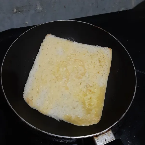 Panggang roti sebentar, lalu balik. Jika perlu beri margarin lagi sesuai selera. Lalu panggang hingga berubah warna, bolak balik.