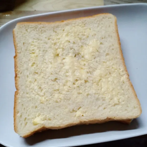Tumpuk roti menjadi satu. Kemudian oles lagi dengan margarin.
