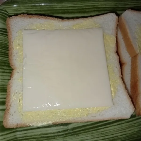 Olesi roti tawar dengan margarin letakkan Mozarella di atasnya lalu tutup dengan roti.
