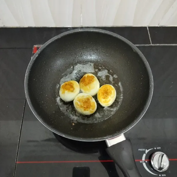 Rebus telur hingga matang, lalu kupas dan goreng hingga berkulit. Sisihkan.