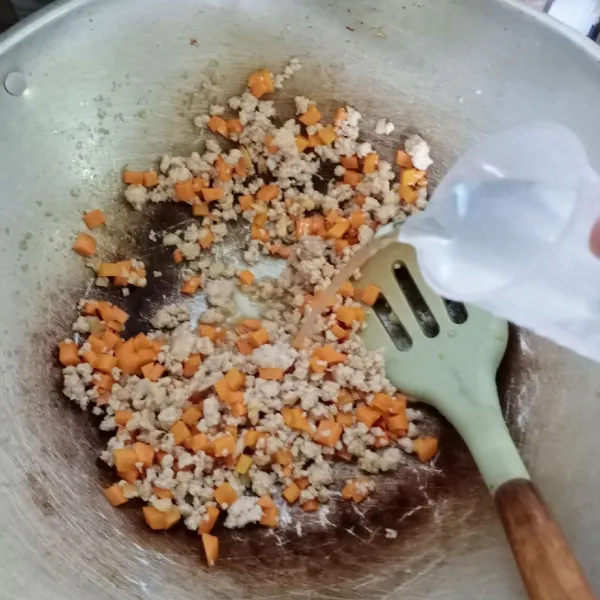 Masukkan wortel, aduk rata. Kemudian tuang air. Beri garam, kaldu jamur, gula, kunyit bubuk dan kari bubuk. Aduk rata, masak sampai wortel empuk.