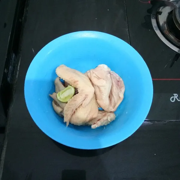 Potong sayap ayam menjadi 2 bagian lalu beri air jeruk nipis, diamkan sesaat dan cuci hingga bersih.