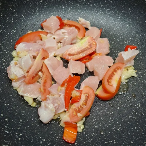 Masukkan ayam dan tomat. Tumis sampai ayam berubah warna.