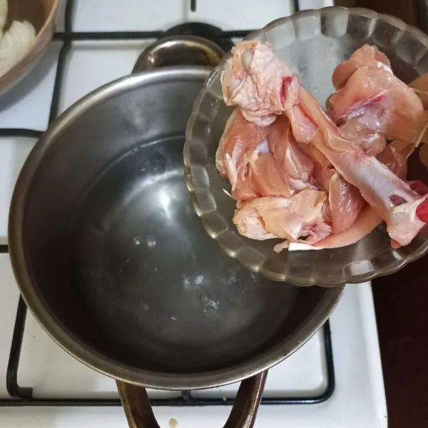 Rebus air dalam panci, masukkan potongan daging paha ayam, masak hingga berubah warna.