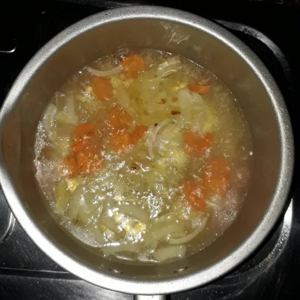 Tambahkan air, masak hingga mendidih lalu masukkan wortel. Masak hingga wortel layu.