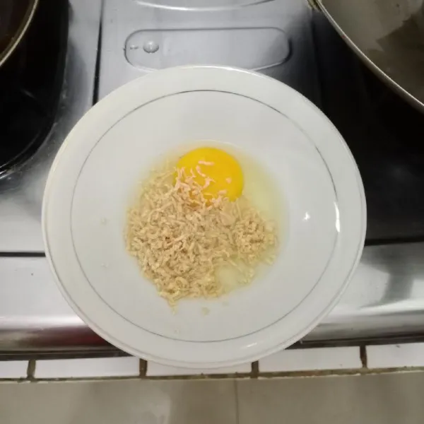 Dalam mangkok, masukkan telur dan tempe parut. Aduk rata.