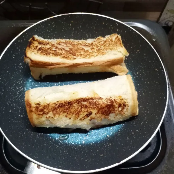 Lelehkan margarin di teflon, panggang roti sampai sisi-sisinya kecoklatan. Angkat dan sajikan.