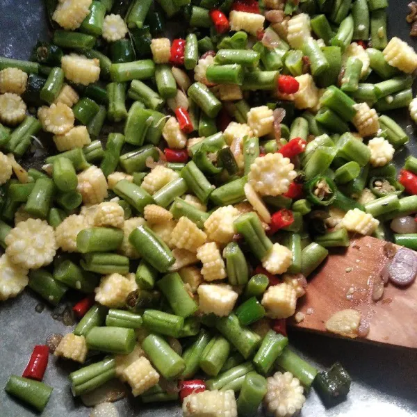 Masukkan daun salam, lengkuas, buncis dan putren. Aduk rata. Masak hingga buncis sedikit layu.