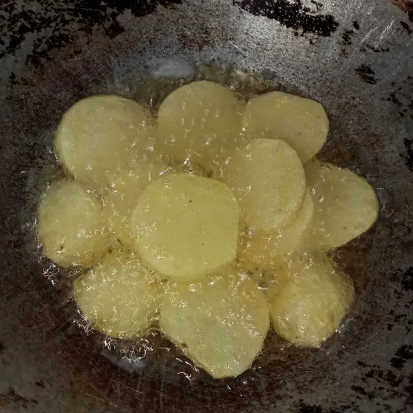 Kupas,iris kentang kemudian goreng hingga berkulit.