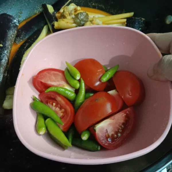Tambahkan cabe rawit hijau dan tomat. Masak sampai kuah menyusut dan bumbu meresap.