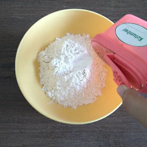 Campur tepung terigu, tepung maizena, dan ketumbar bubuk dalam satu wadah .