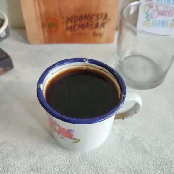 Seduh kopi hitam dengan air panas mendidih, kemudian biarkan sebentar hingga kopi mengendap.