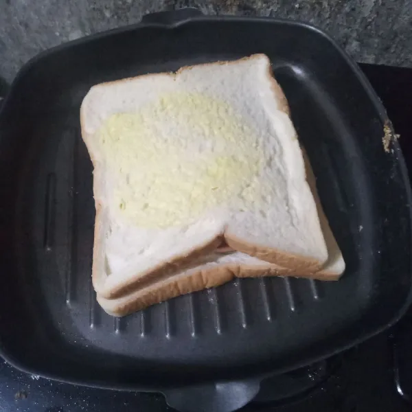 Tutup roti, tekan-tekan lalu letakkan di atas grill pan.