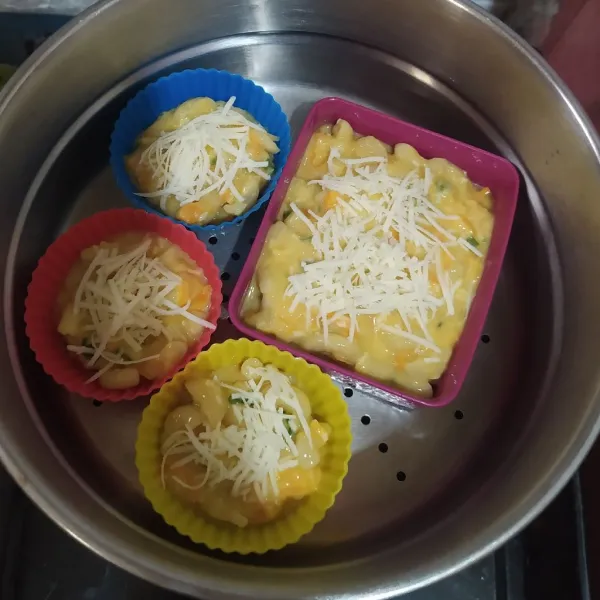 Letakkan di wadah tahan panas yang sudah diolesi margarin. Beri keju parut diatasnya lalu kukus selama 30 menit.