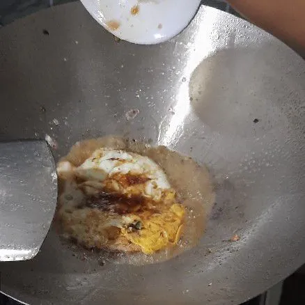 Aduk jadi satu kecap asin, manis, saus tiram, air dan minyak wijen lalu tuang ke dalam telur.