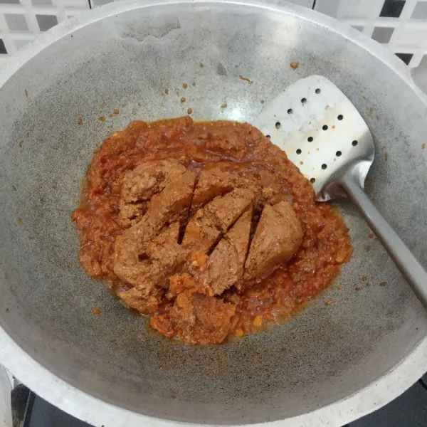 Masukkan kacang tanah yang sudah digiling, masak hingga tercampur rata.